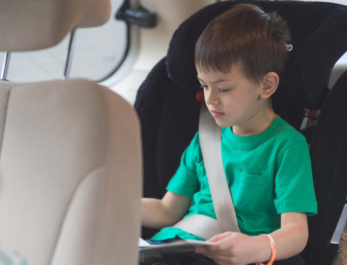 Little boy reading during road trip