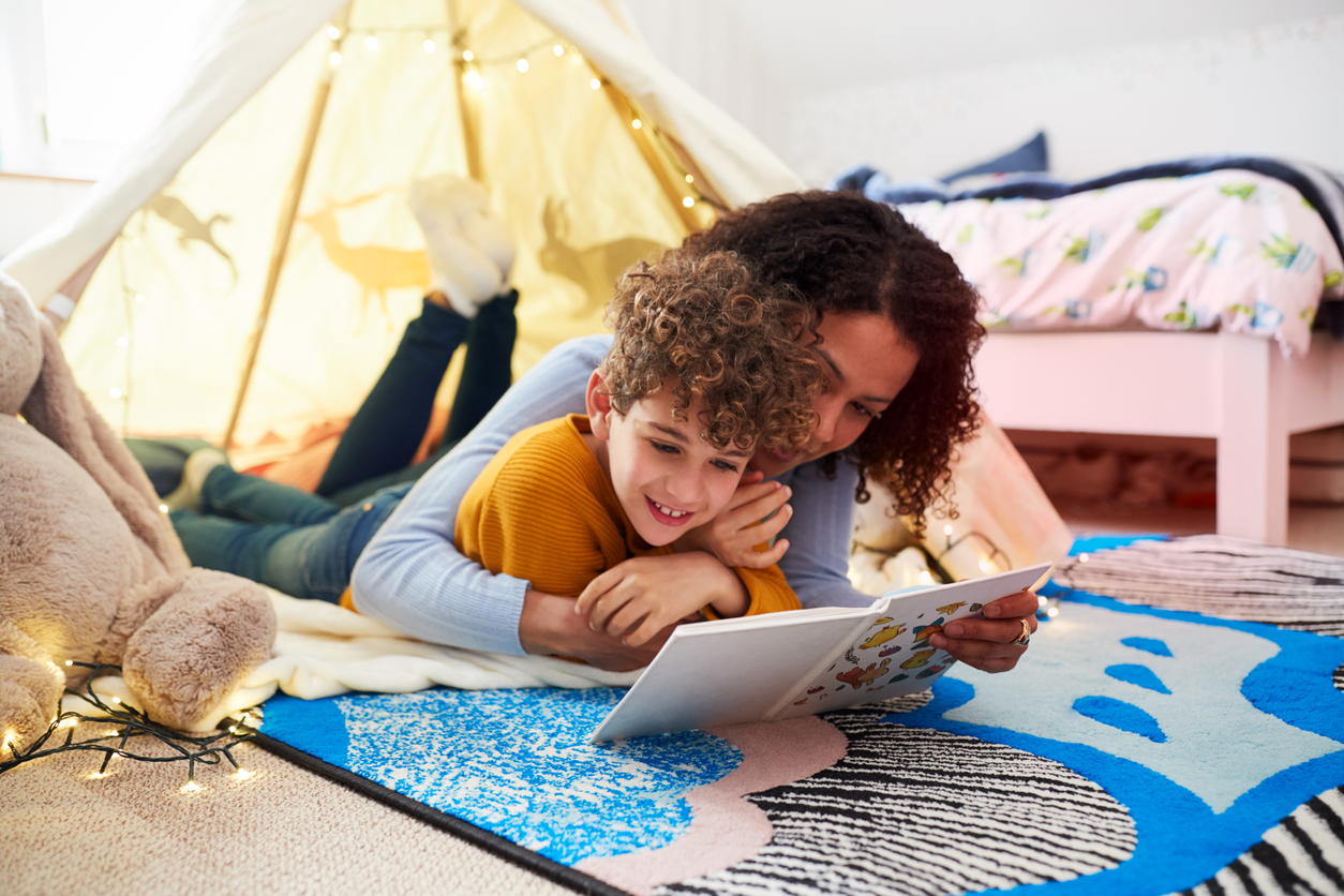 Mom and son reading together in a homemade fort